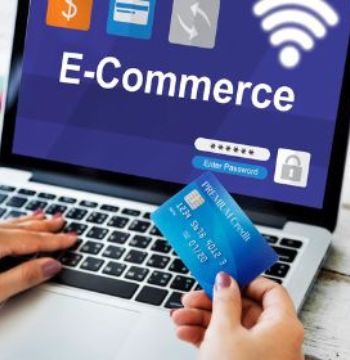 A lady opens an eCommerce website on a laptop and hold a card in hand for a transaction